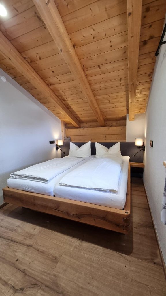 Gemütliches Schlafzimmer mit Doppelbett und Holzdecke im Appartement Wälderhof, Kaprun.