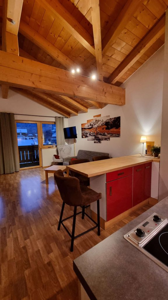 Moderne Ferienwohnung mit Holzdecke, offener Küche und gemütlichem Wohnbereich in Kaprun.